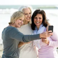 three ladies taking a picture at the beach