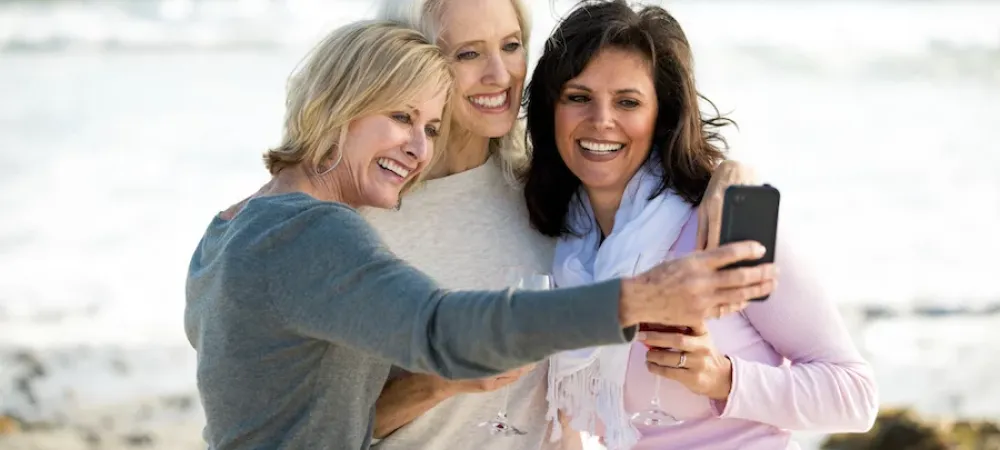 three ladies taking a picture at the beach